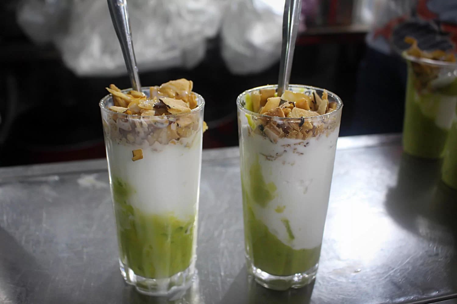 Creamy green avocado ice cream, garnished with fresh avocado slices and a drizzle of coconut milk